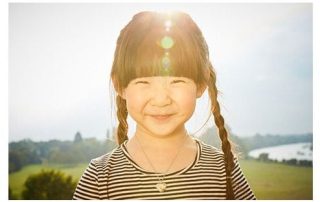 girl smiling with heart necklace