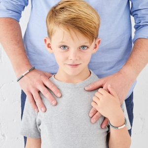 young boy with dad and matching leather bracelets